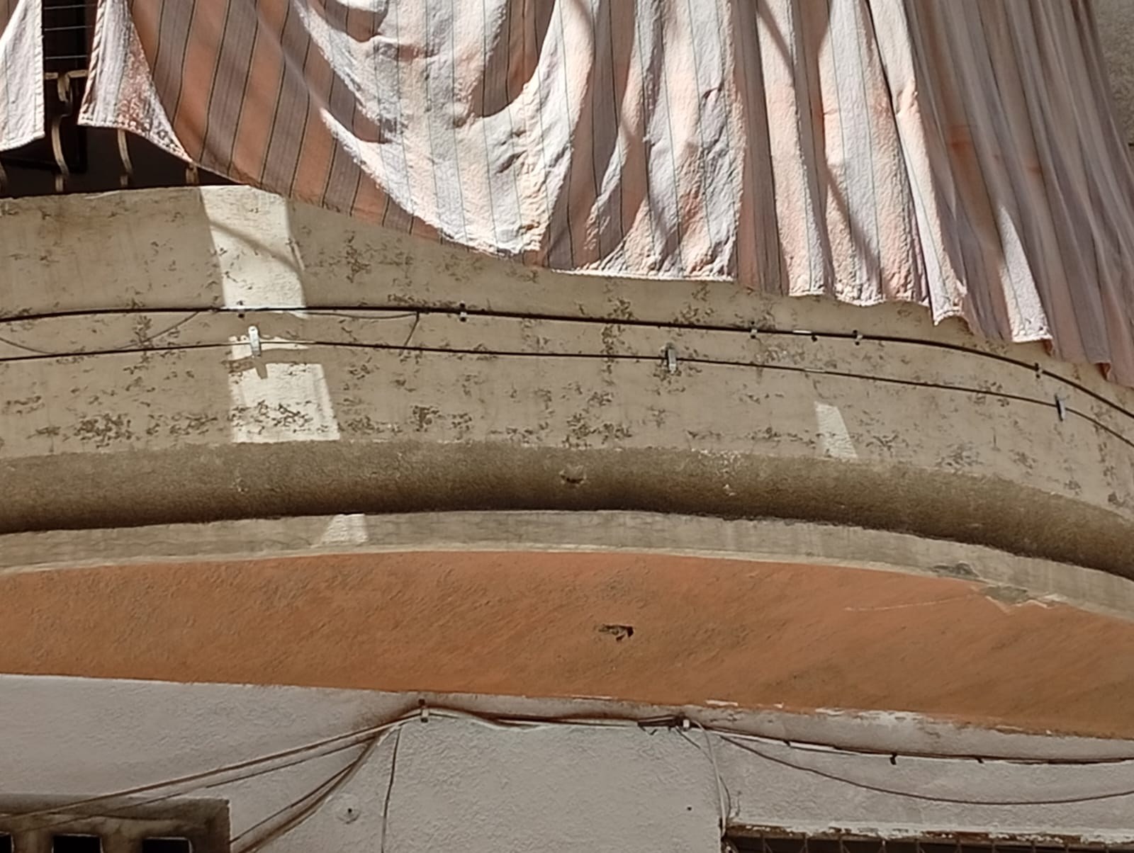 Clipped cable route below balcony
