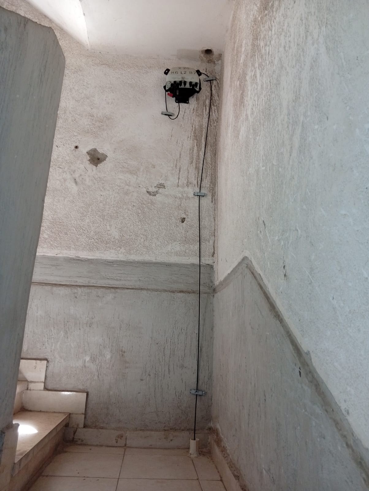 Vertical FTTH cable route through stairwell